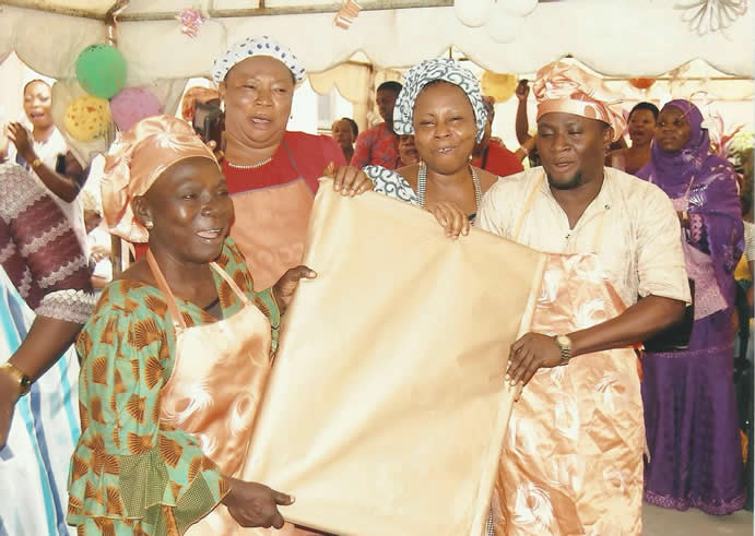 Trainees presenting fabric at a graduation ceremony
